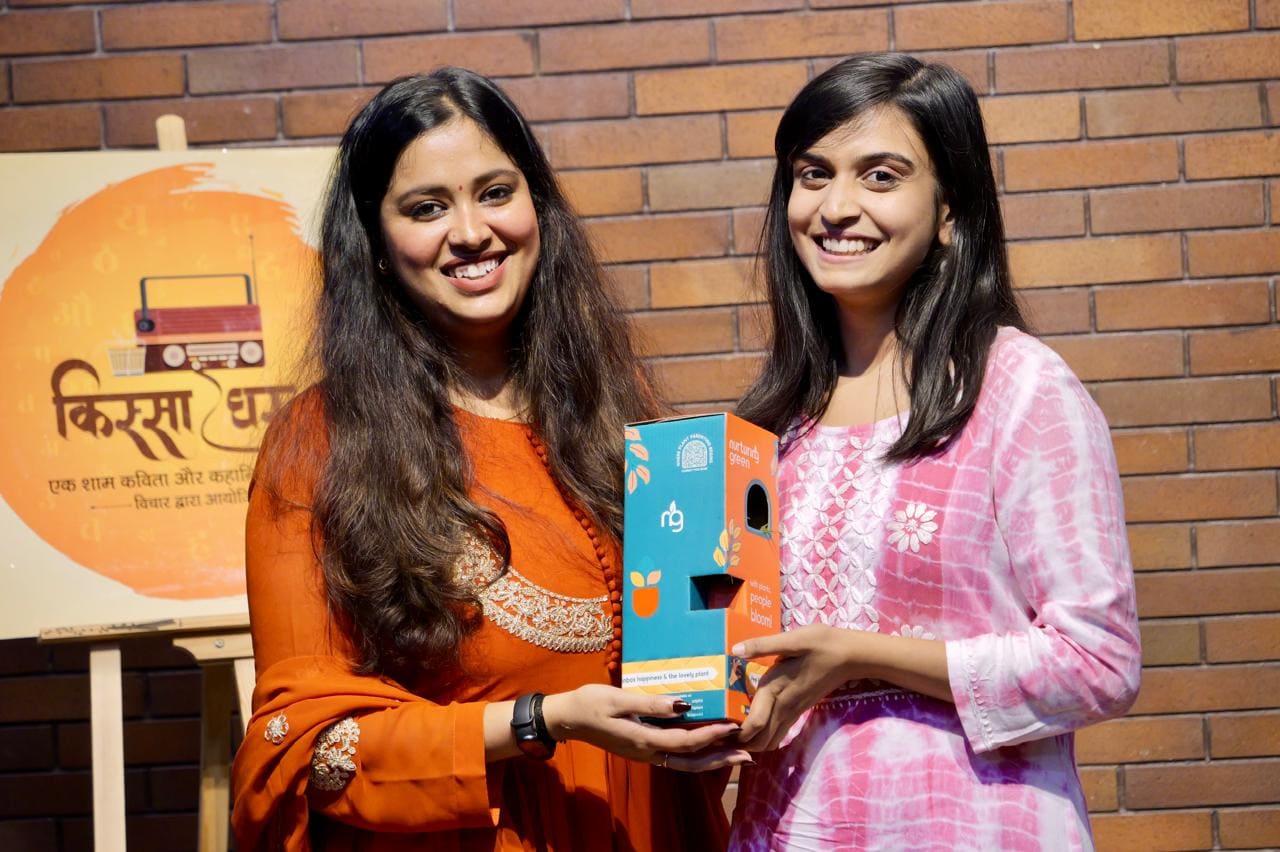 A Qissa Ghar organiser presenting a prize to a performer on stage